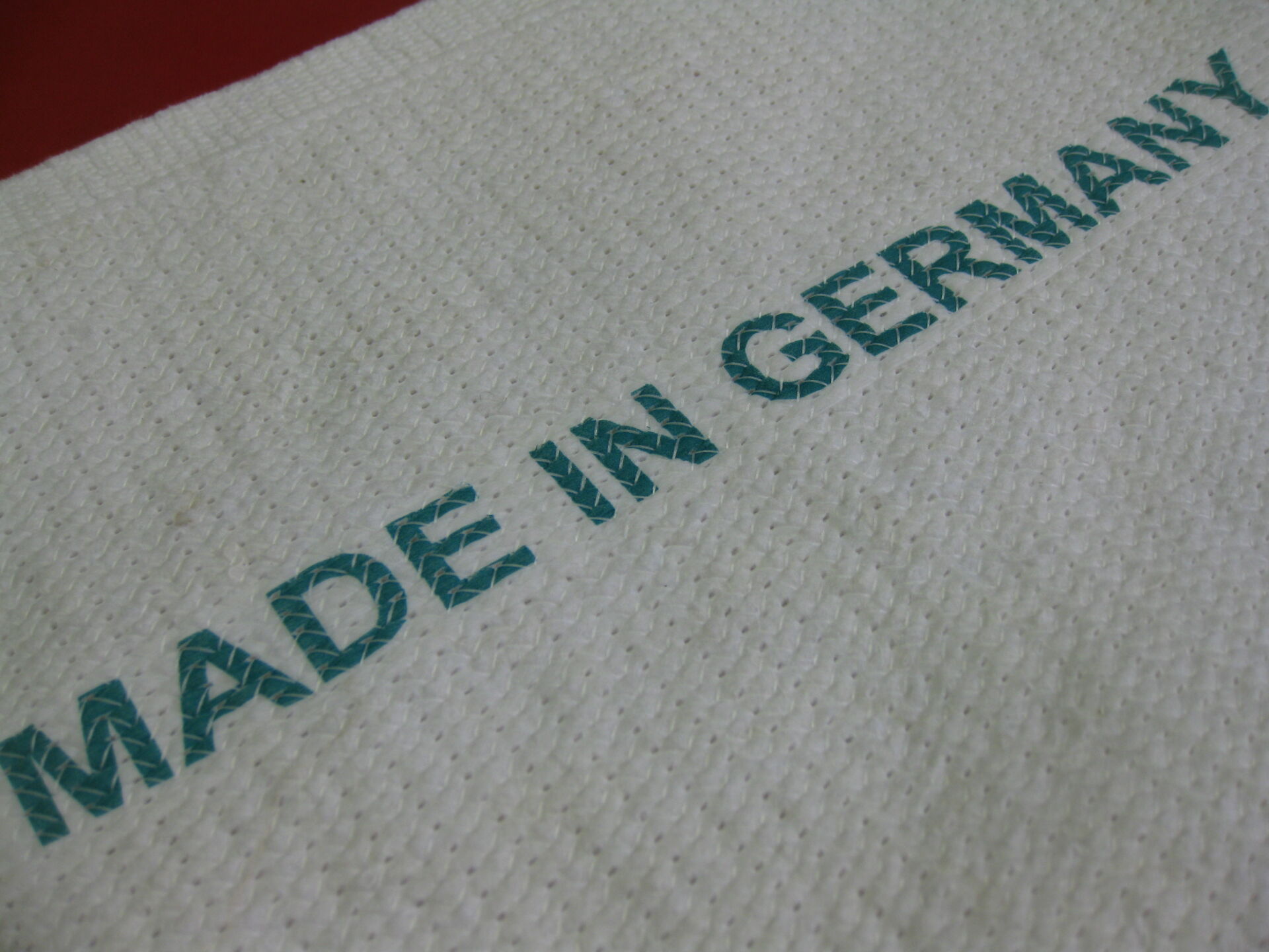 Nahaufnahme eines gewebten Herkunftsetiketts an einem hochwertigen Reinigungstextil aus deutscher Produktion